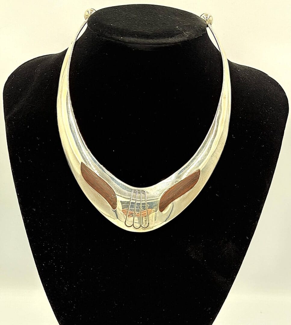 Silver necklace with hand design on display.