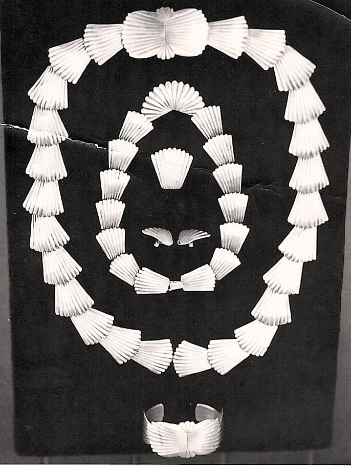 Shell jewelry set displayed on black background.