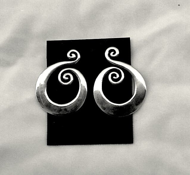 Silver spiral earrings on black background.