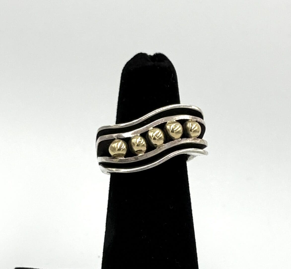 Silver and gold wavy band ring display.