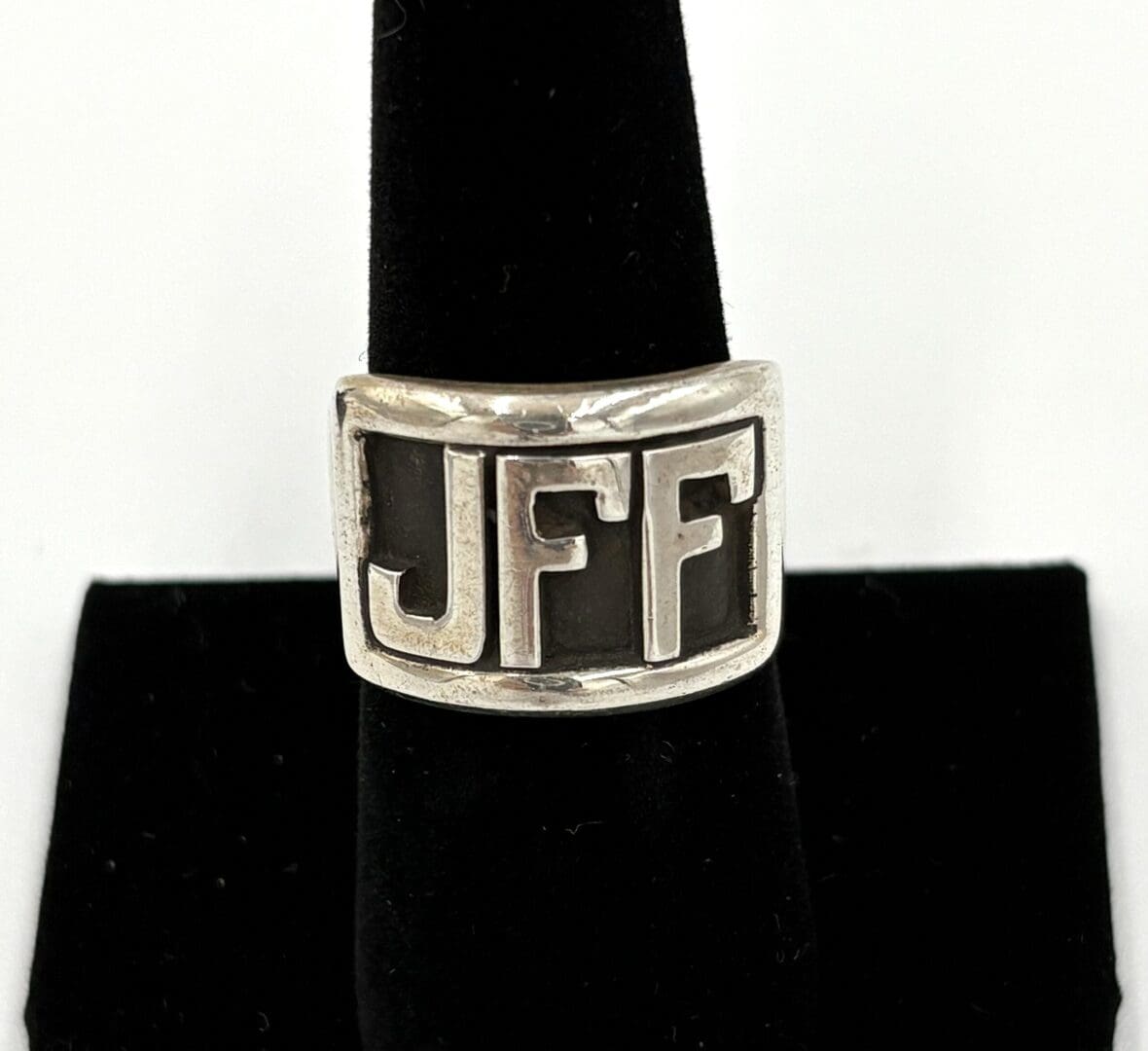 Silver ring with "JFF" on black background.