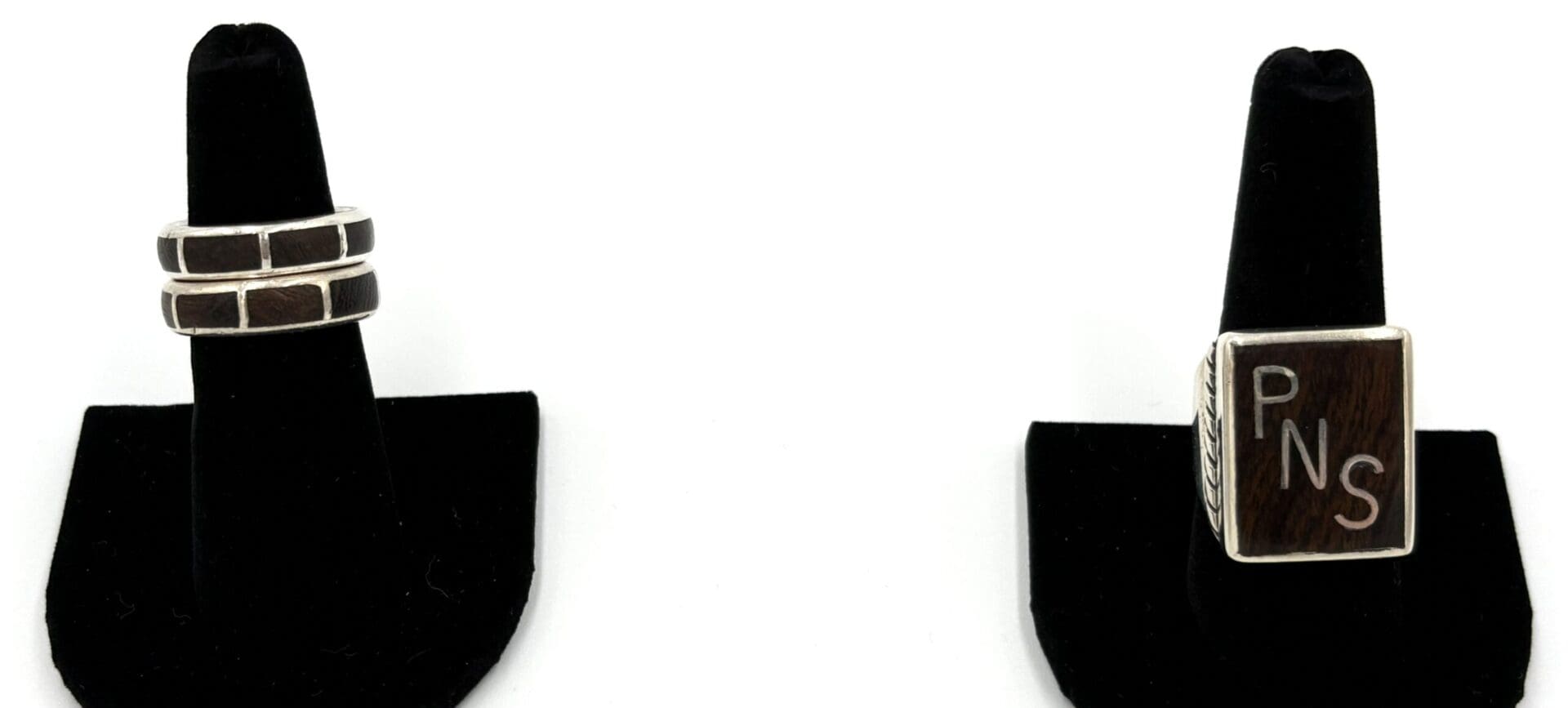 Two rings displayed on black stands.