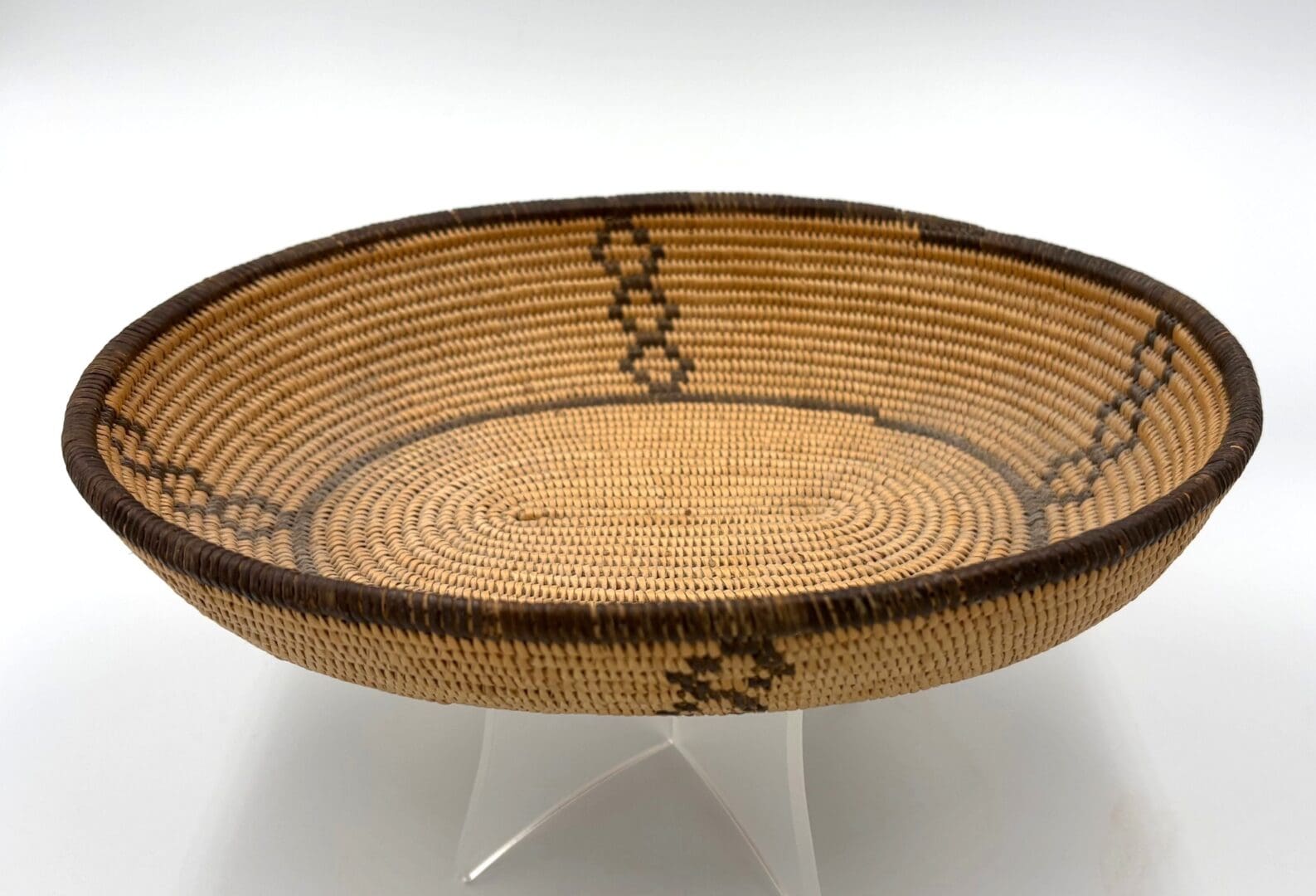 Woven basket with geometric patterns displayed upright.