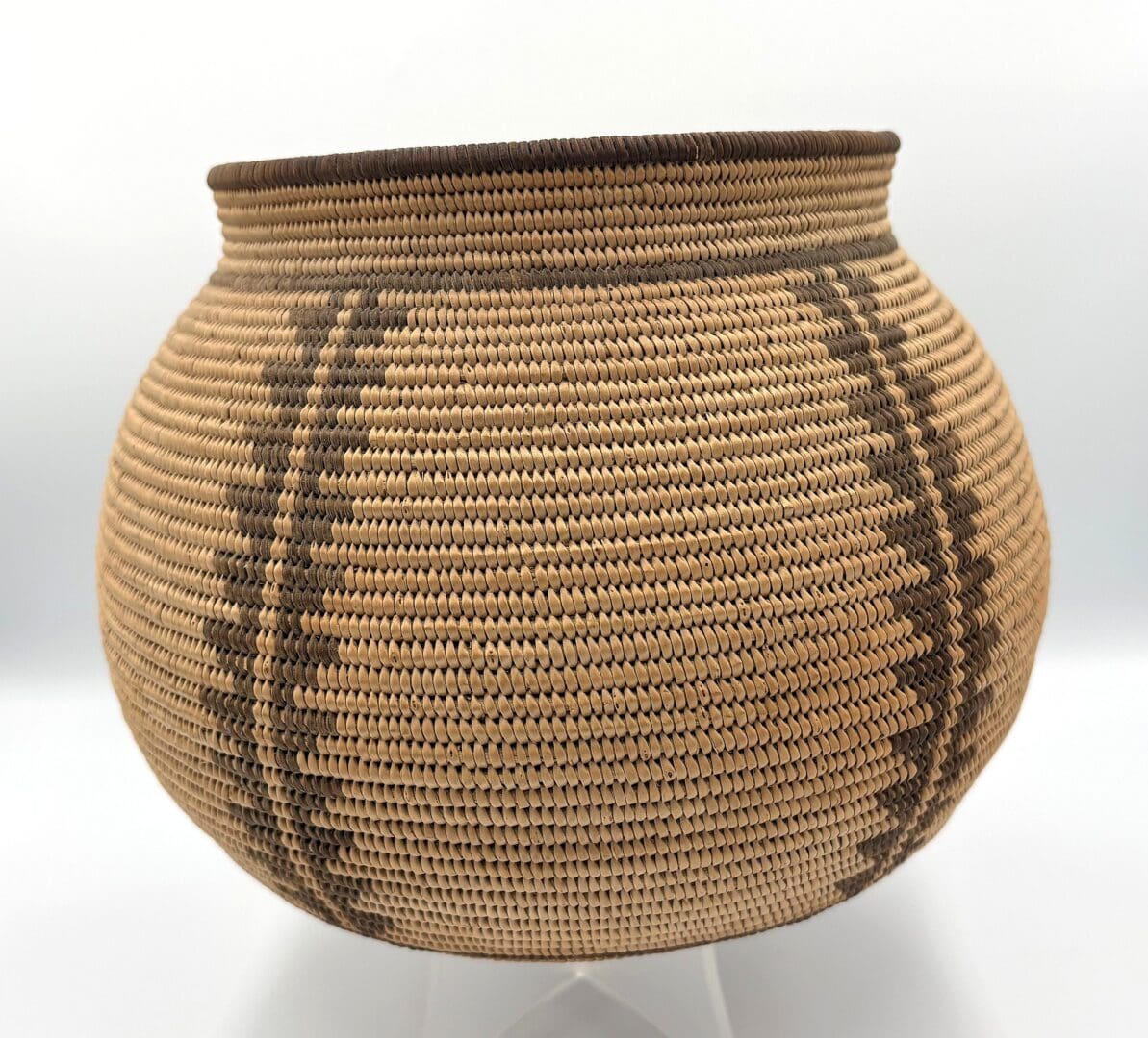 Woven basket with geometric patterns, round shape.