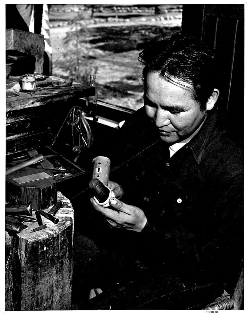 Man crafting a wooden object in workshop.