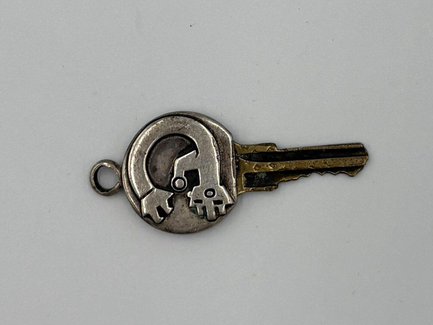 Silver key with unique circular design.
