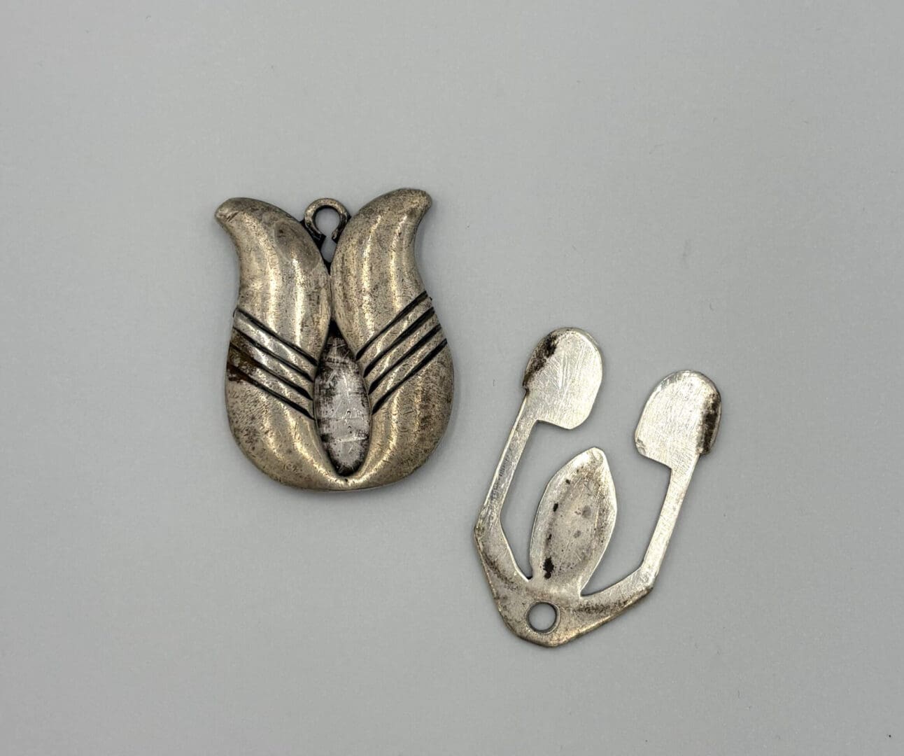 Silver pendant and abstract metal piece.