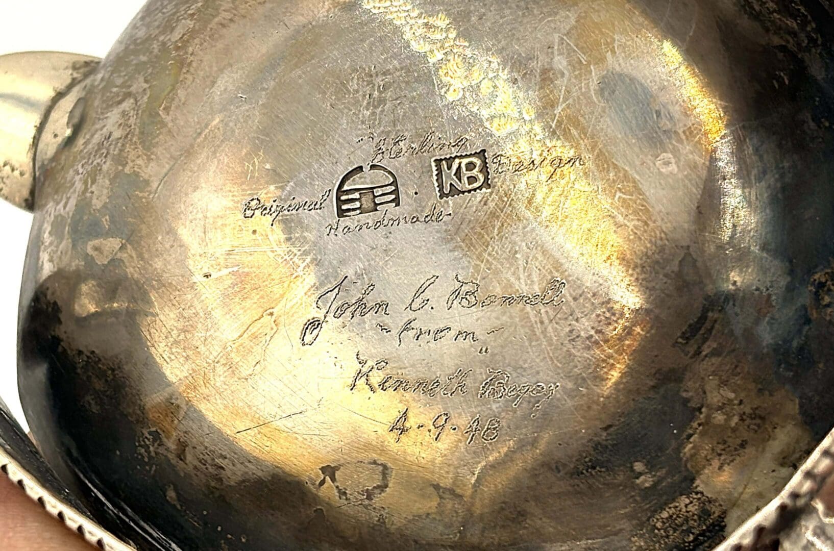 Engraved silver object with inscriptions and markings.