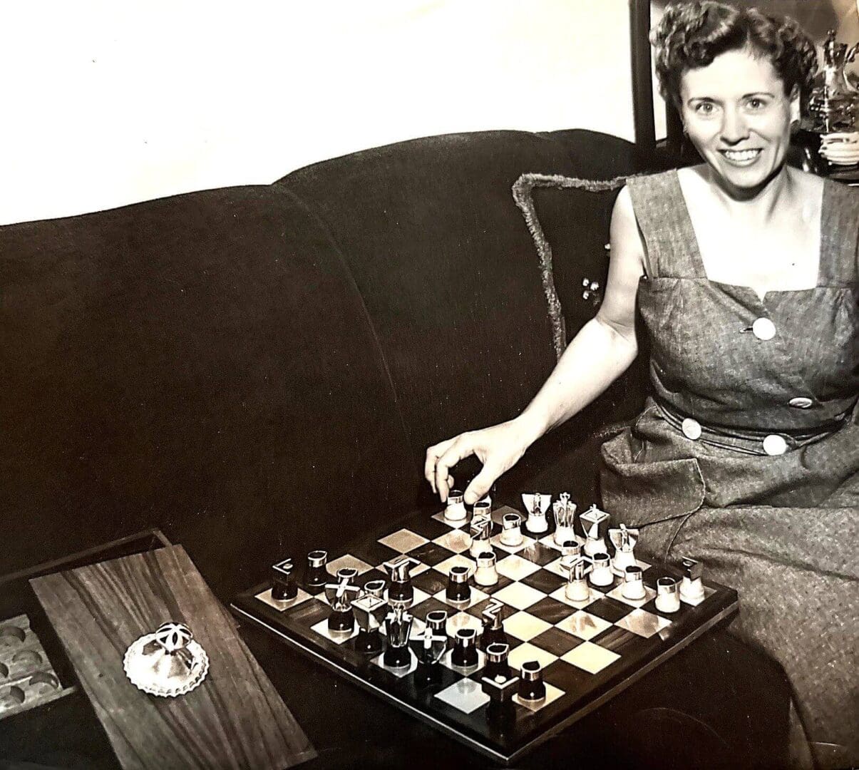 Woman playing chess on a couch.