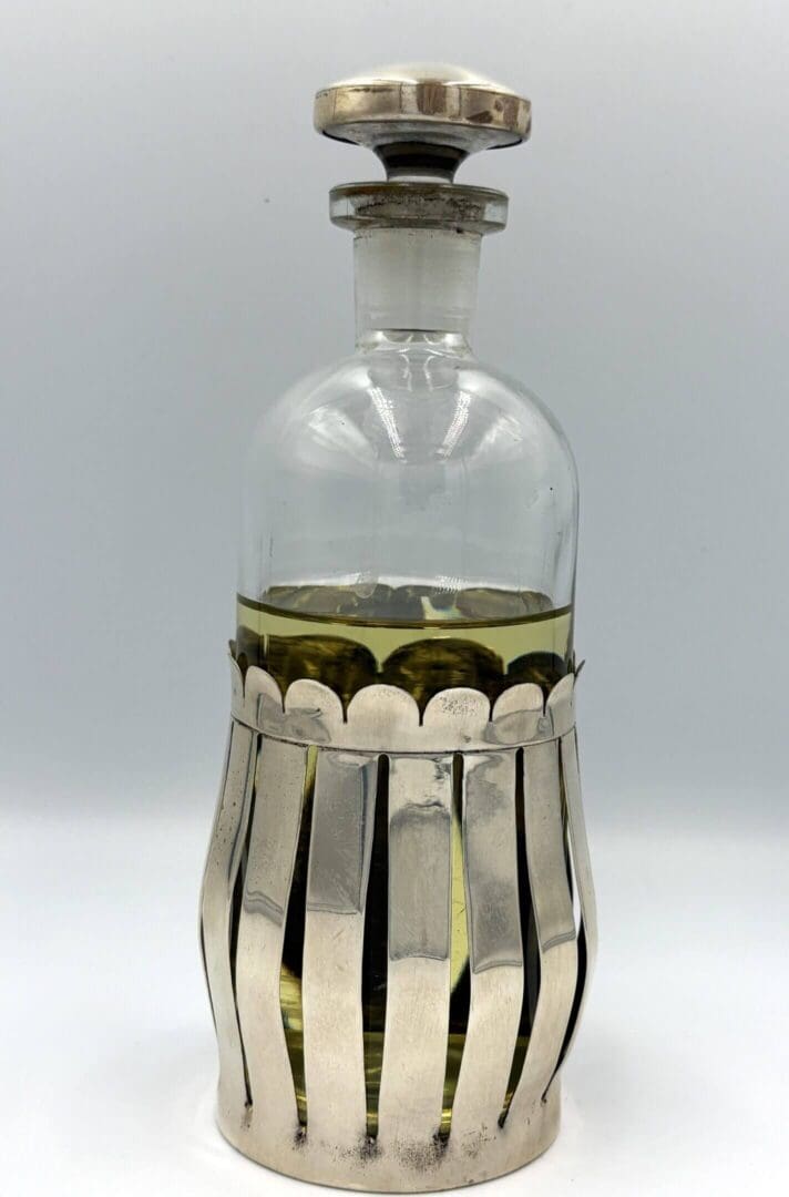 Glass bottle with decorative silver holder.