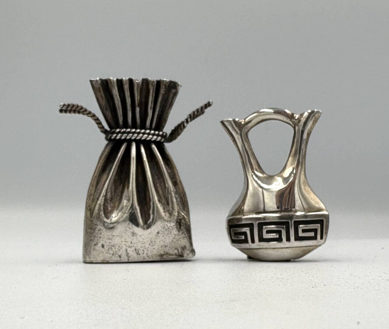Two decorative silver miniature objects displayed.