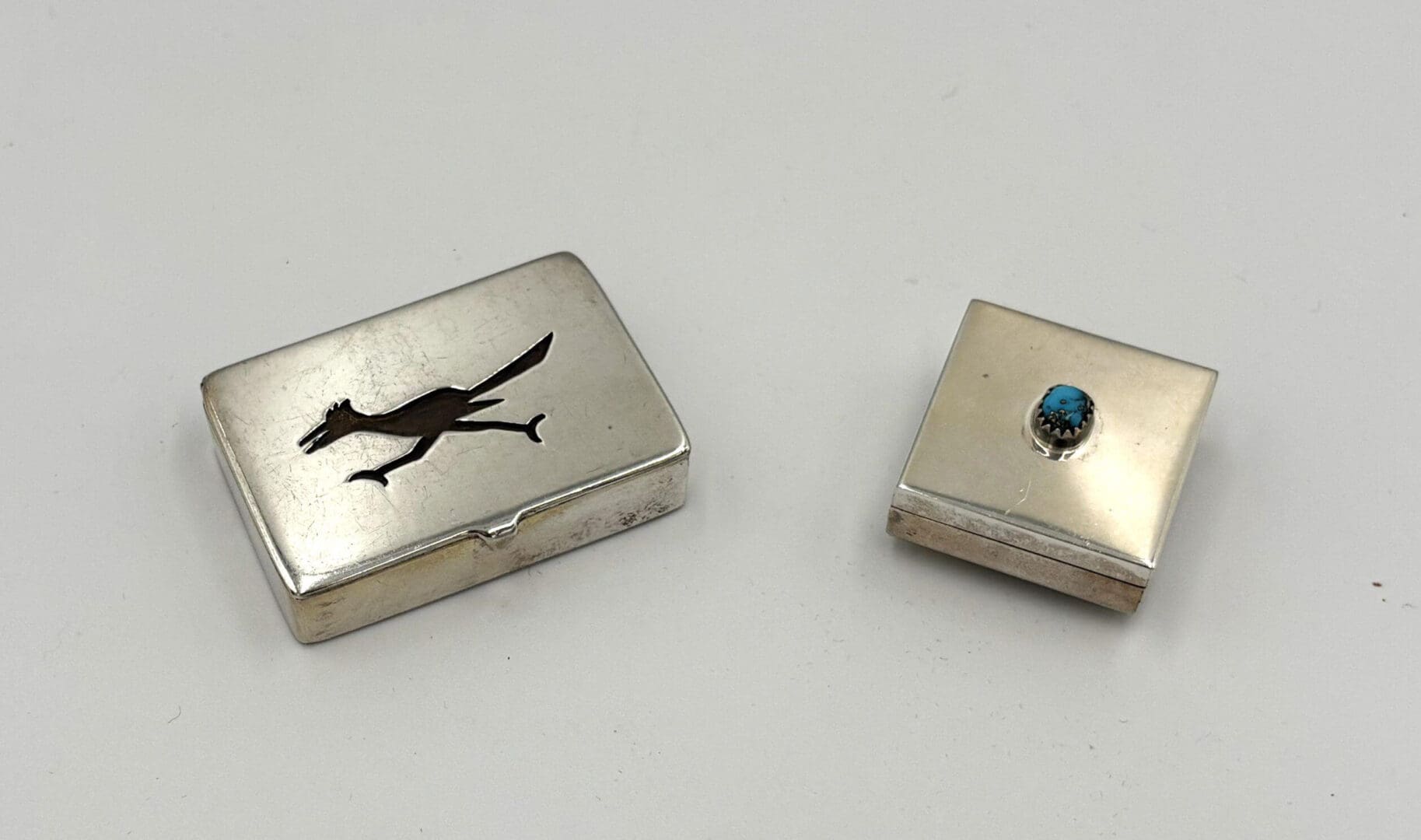 Two silver boxes with unique designs.