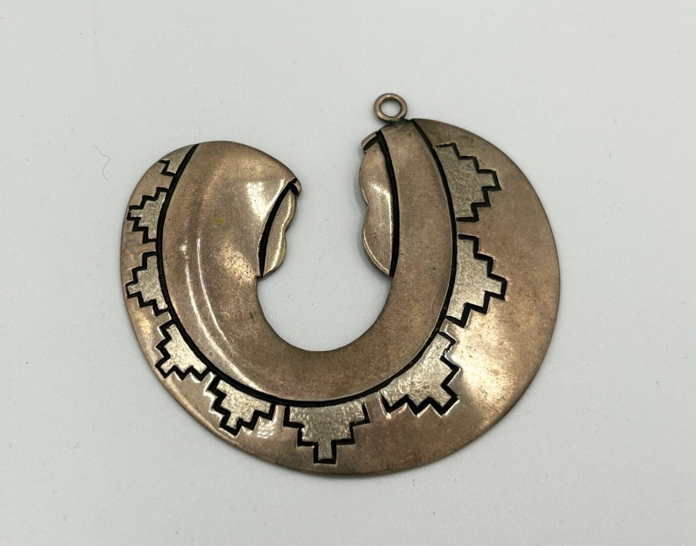 Bronze pendant with geometric patterns.