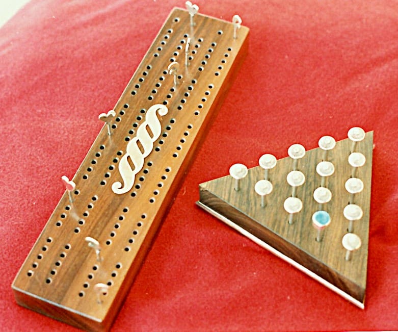 Wooden cribbage board and peg solitaire game.