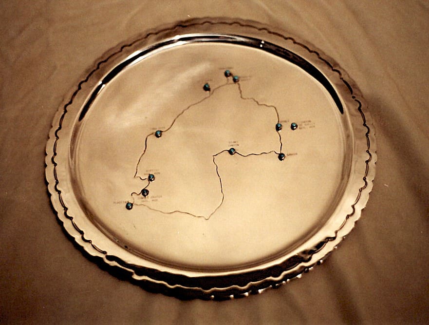 Silver platter with engraved route and pins.