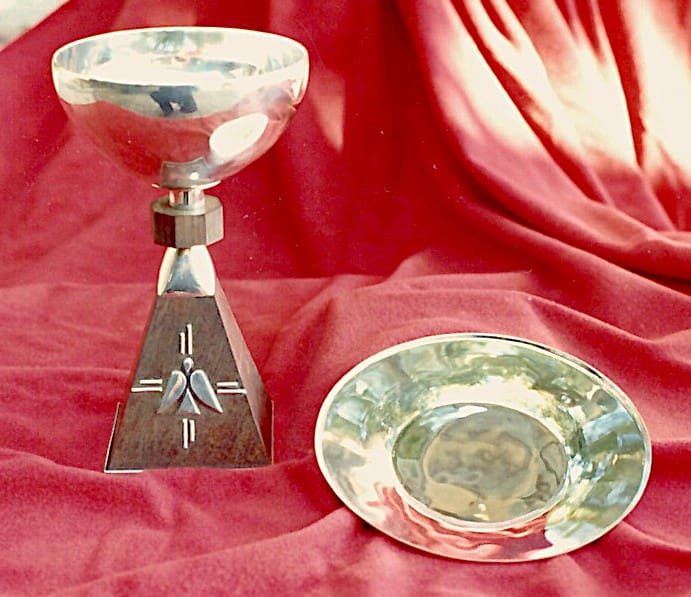 Silver trophy with plate on red fabric.