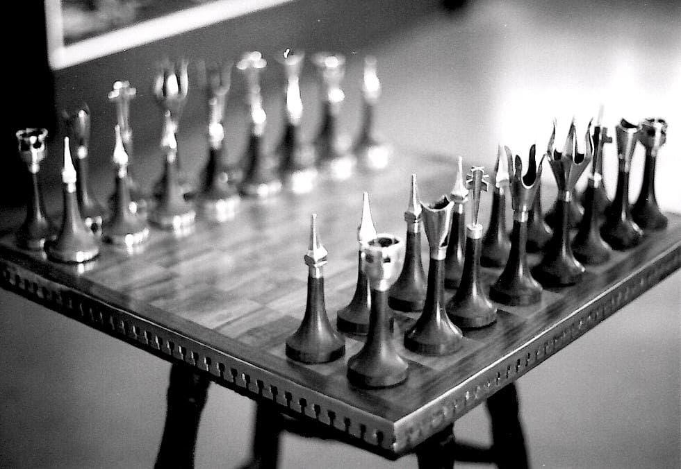 Unique chess set on a wooden board.