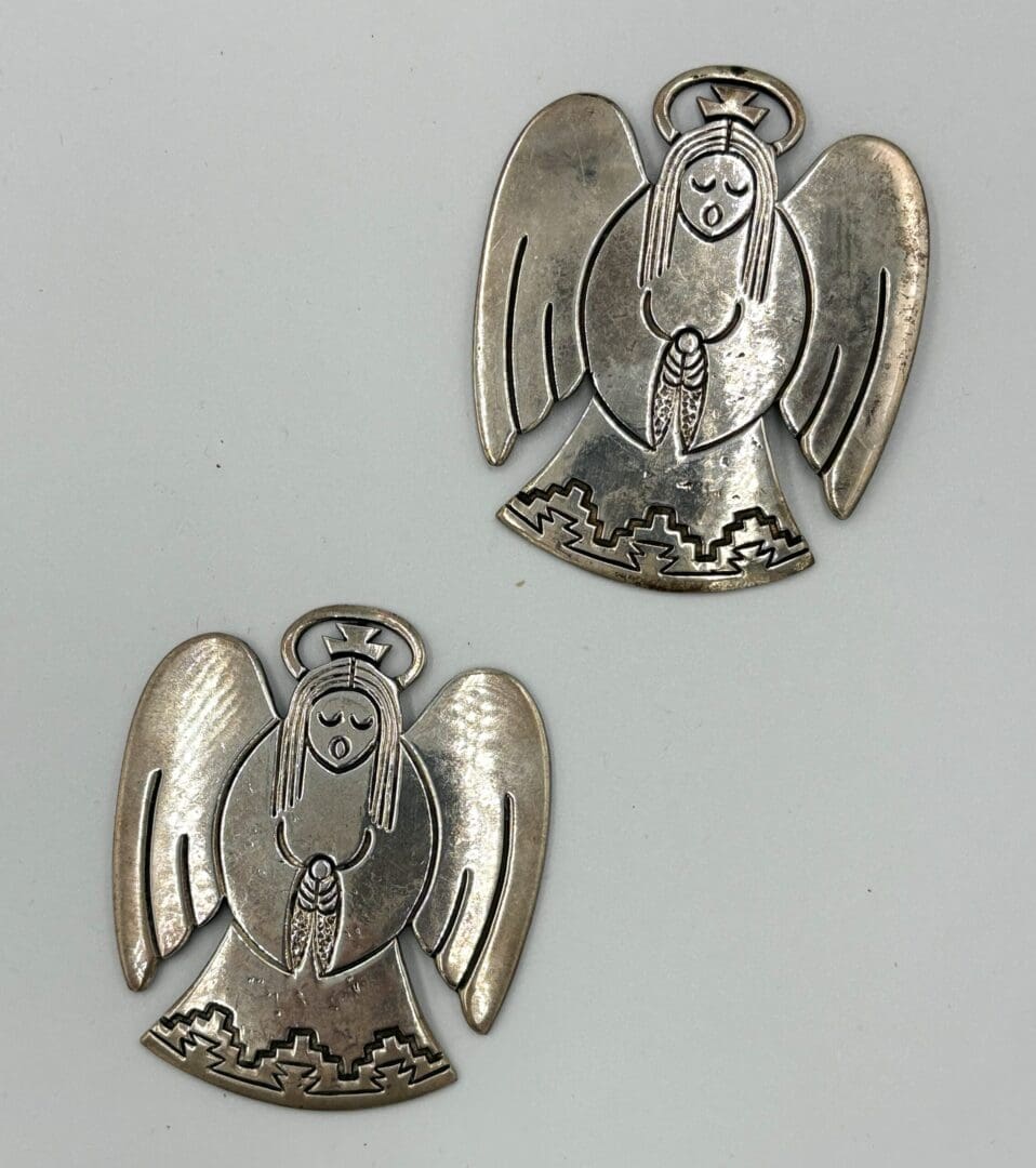Two silver angel ornaments with wings.