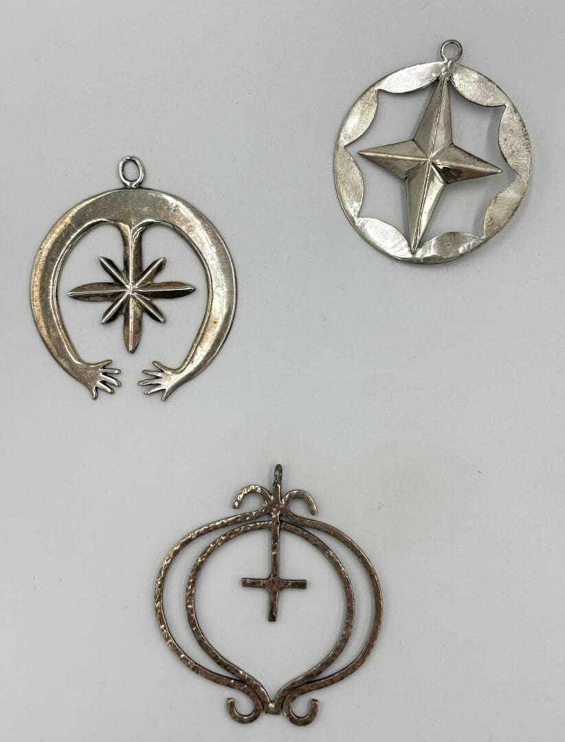 Three silver metal star-shaped pendants.