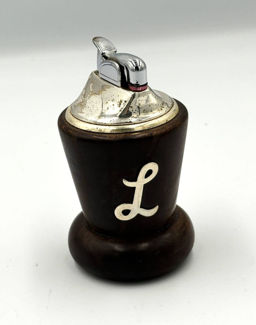 Vintage lighter with letter "L" design.