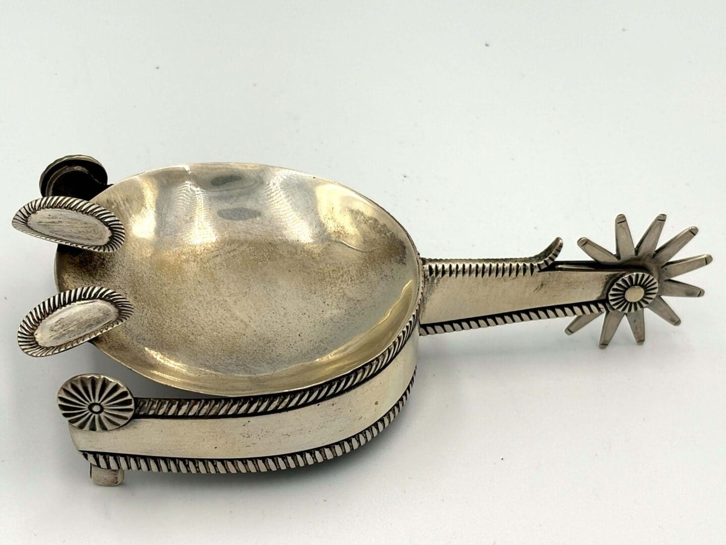 Ornate silver spoon with decorative handle.