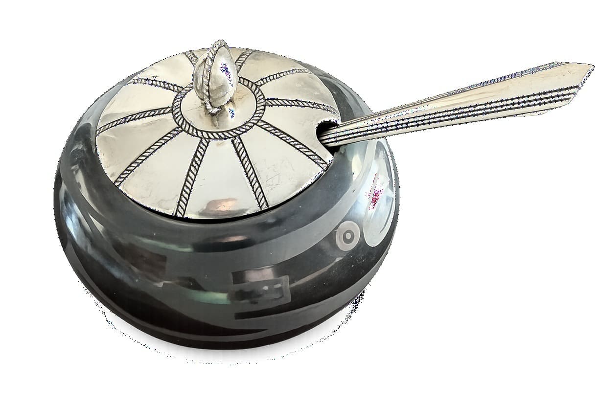 Ornate silver sugar bowl with spoon